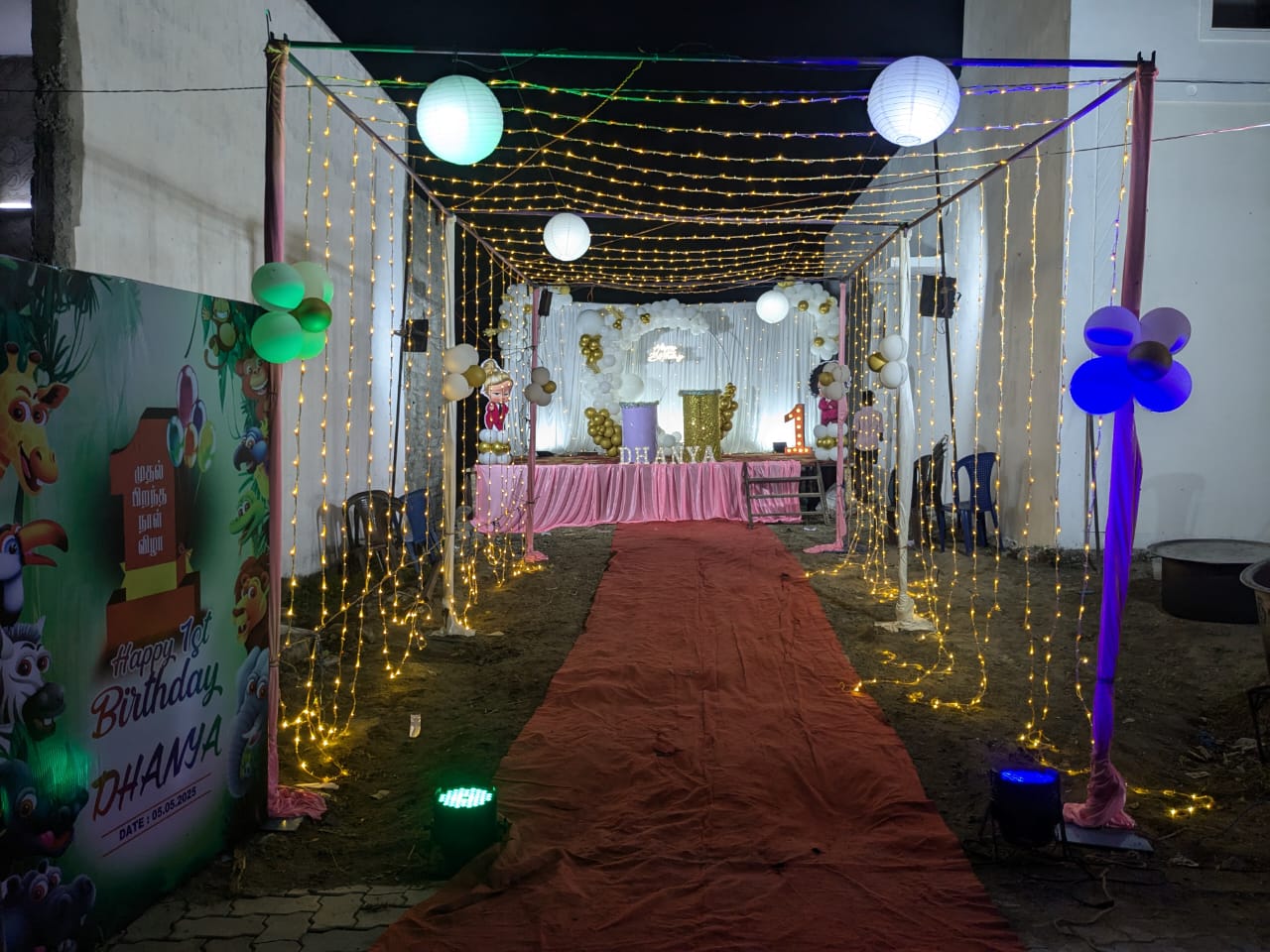 Outdoor birthday decoration featuring a fairy-light walkway, lantern hangings, stage balloon décor, and themed backdrop, priced at ₹16,000.