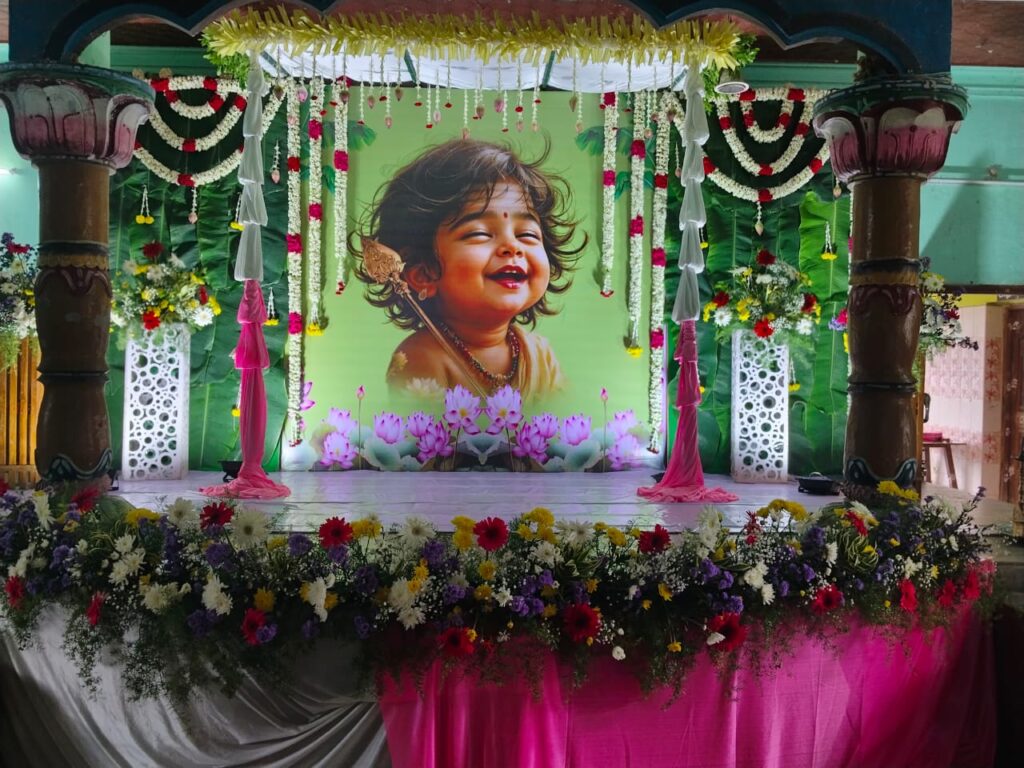 Complete baby shower stage with flower borders, garlands, and central portrait - South India
