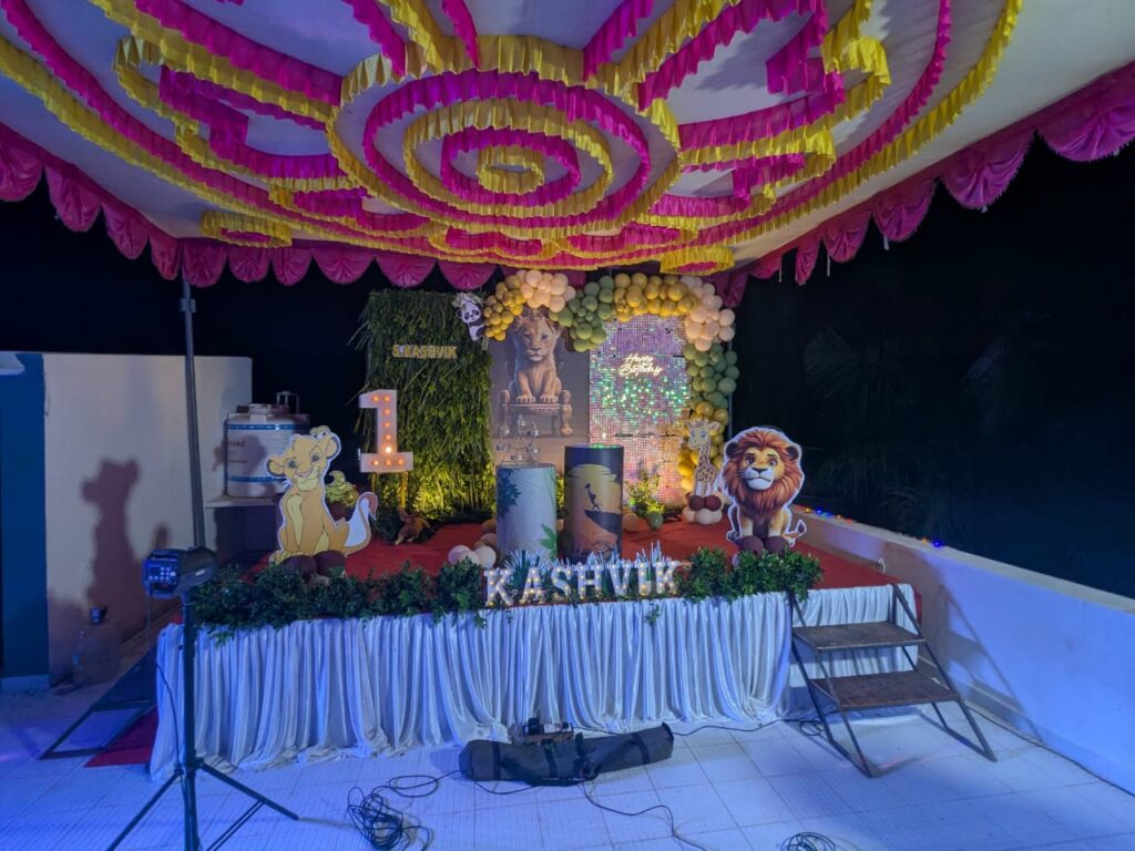 Lion King theme birthday stage with jungle backdrop, balloon arch, character standees, and marquee lights at Nolambur, Tindivanam.