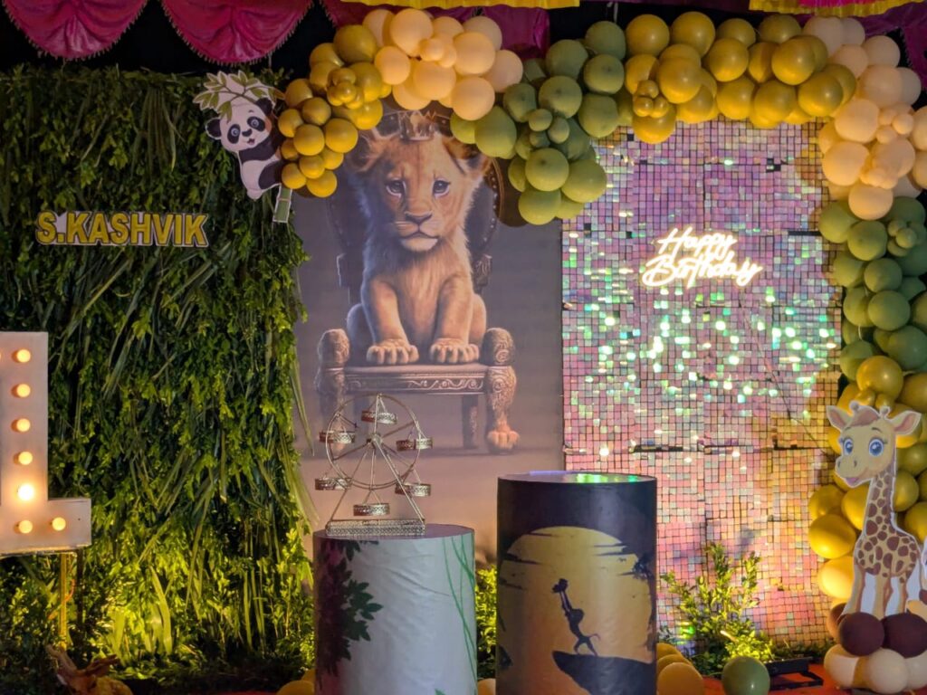  Side angle view of the Lion King birthday stage featuring jungle-themed props and green backdrop.

