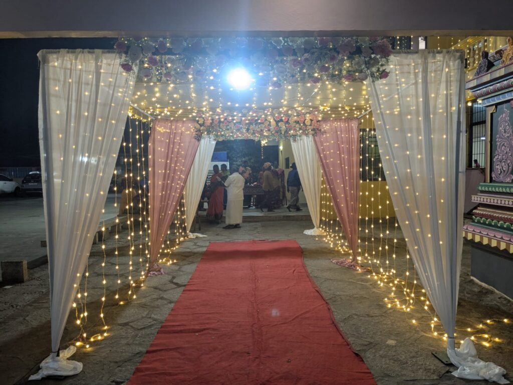 K C M Mahal exterior decorated with serial lights and welcome boards for wedding in Auroville
